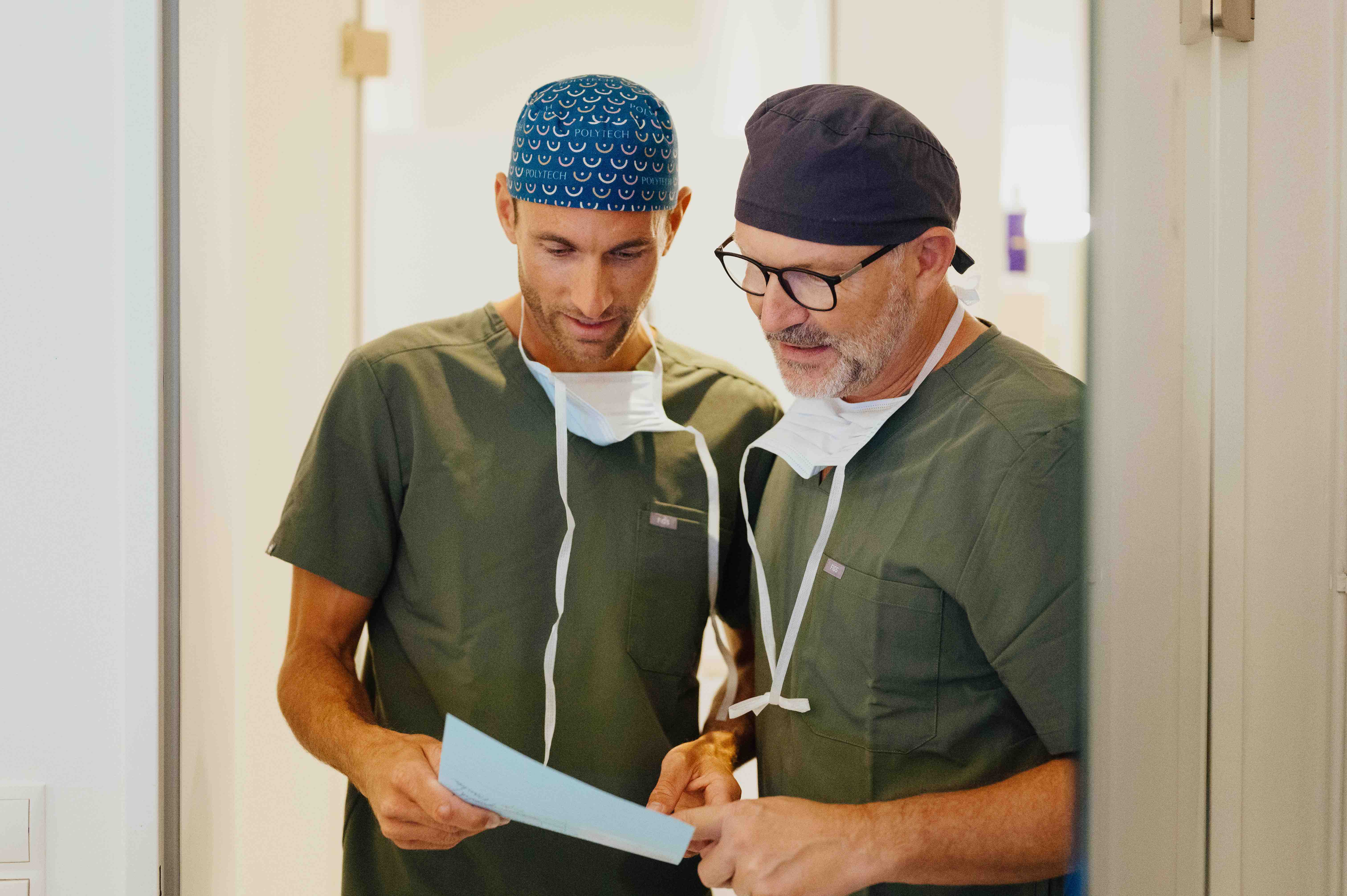 Dr. Bergmann und Dr. Kruess stehen nebeneinander und besprechen eine Behandlung.
