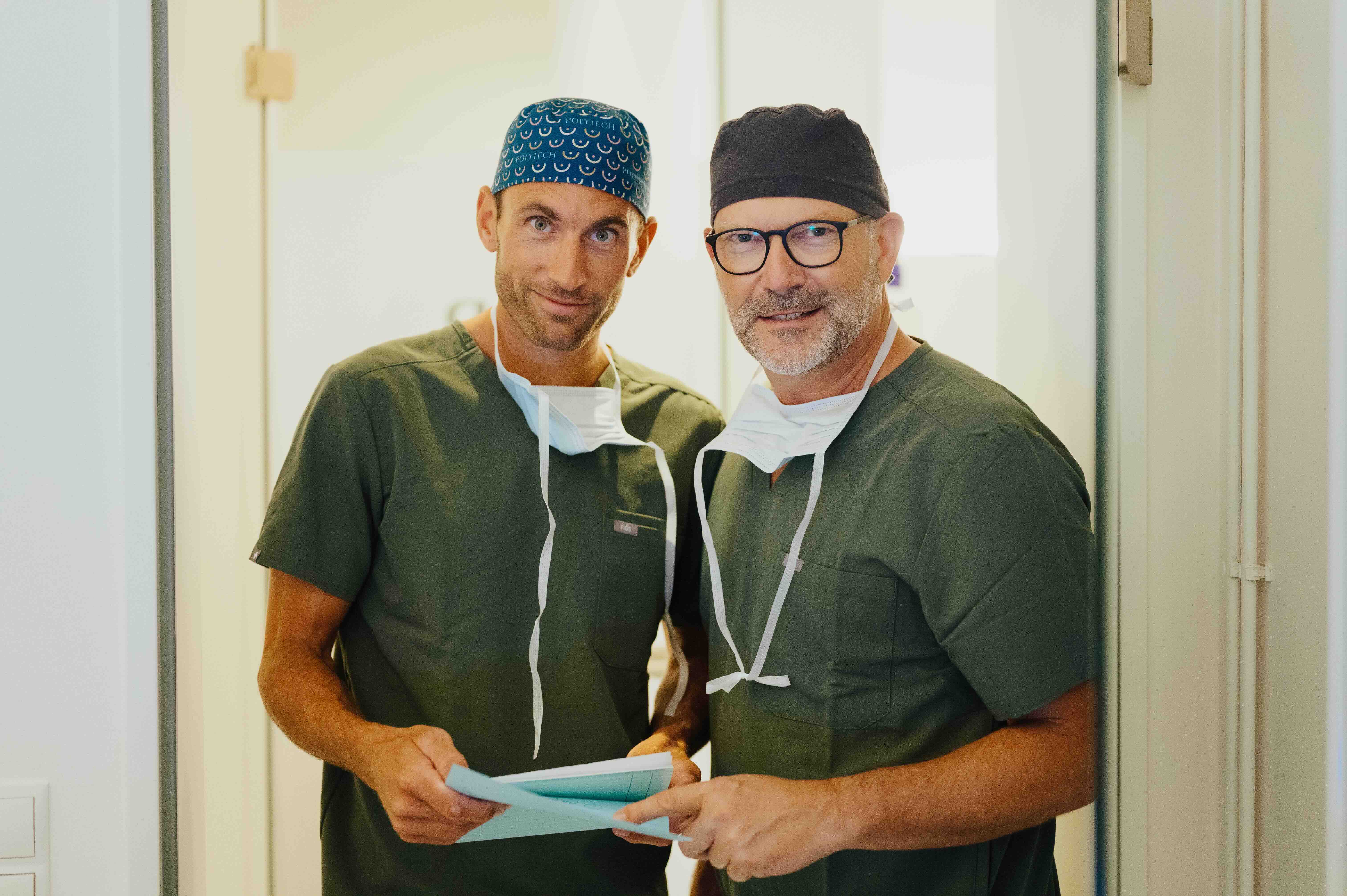 Dr. Bergmann und Dr. Kruess stehen nebeneinander und besprechen eine Behandlung.