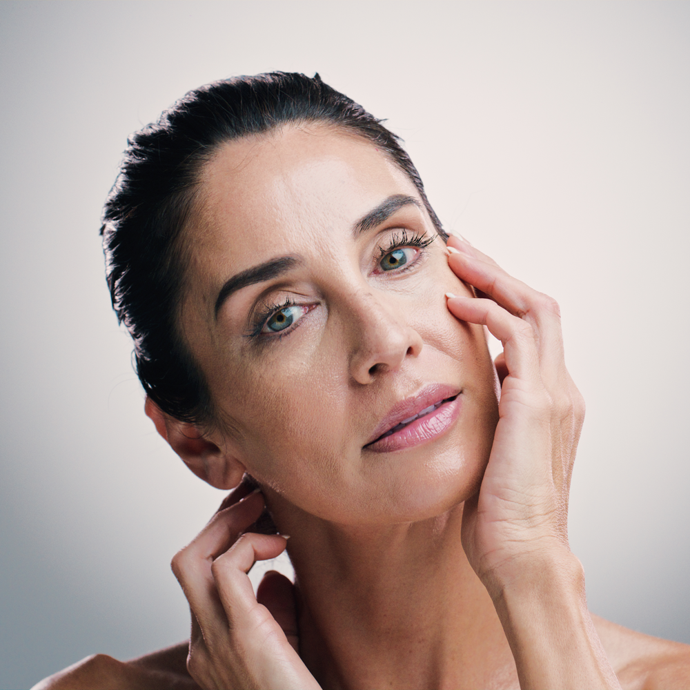 Zufriedene, attraktive Frau, nach einer Anti-Aging Gesichtsbehandlung.